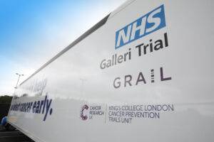 External side of the trials unit showing the NHS Galleri logo, GRAIL logo and CRUK Kings College London logo