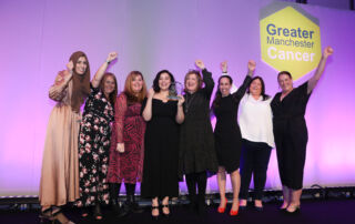 8 women satnd on stage cheering at the GM Cancer Awards