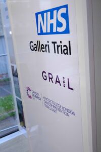 A sign with the words NHS Galleri Trial and the GRAIL and Cancer Research UK logos featured
