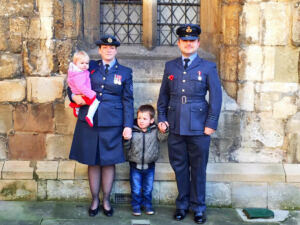 Dawn Turner and family. Dawn holds her daughter on her hip and holding hands with her other child who is also holding hands with a man in RAF uniform
