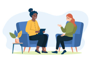 Two cartoon characters a black woman and a white woman sit in arm chairs talking to each other in a counselling session