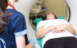 Person lie son a bed of a scanning machine with a health professional stood by them. Words say: a 30 minute appointment could save your life.