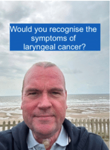 An individual stands on a beach with a cloudy sky and ocean in the background, bearing a text banner above that reads 'Would you recognise the symptoms of laryngeal cancer?'