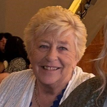 A head and shoulders image of Linda Cotterell, a white woman with short hair in her 70s smiles at the camera