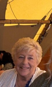 A head and shoulders image of Linda Cotterell, a white woman with short hair in her 70s smiles at the camera