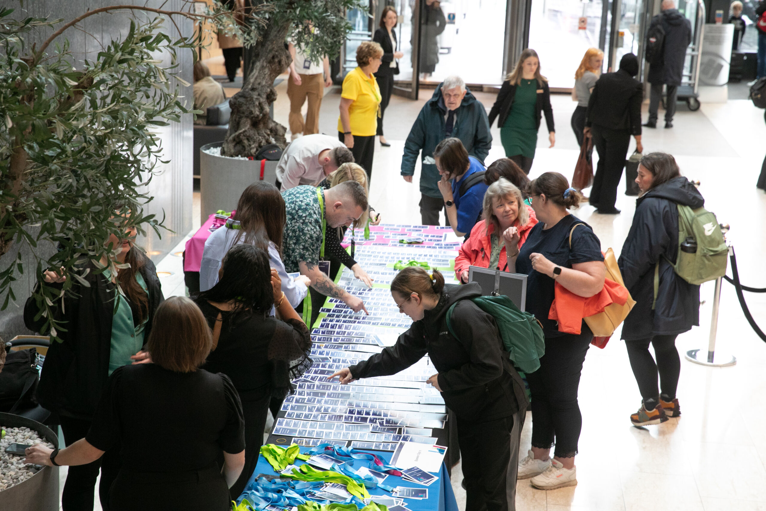 a shot of people collecting their tickets from a table at the Greater Manchester Cancer Conference 2024