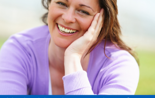 A head and shoulders image of a woman with brown hair sat outside with greenery behind her smiling and resting her head on her hand. Text reads: Had a bleed or spotting after menopause? Self refer for a hospital check