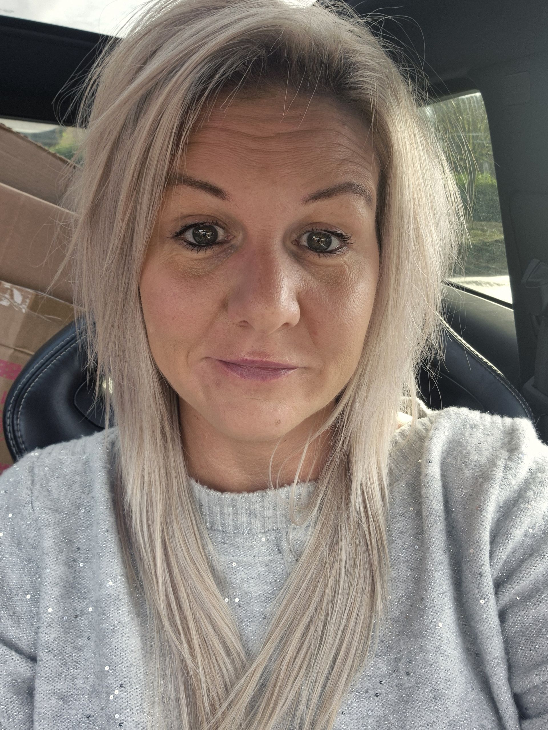 A white woman in a jumper with long blonde hair