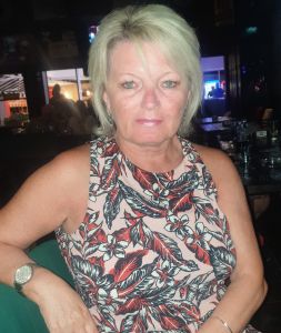 Sue, a white women with blonde hair and a short sleeve top