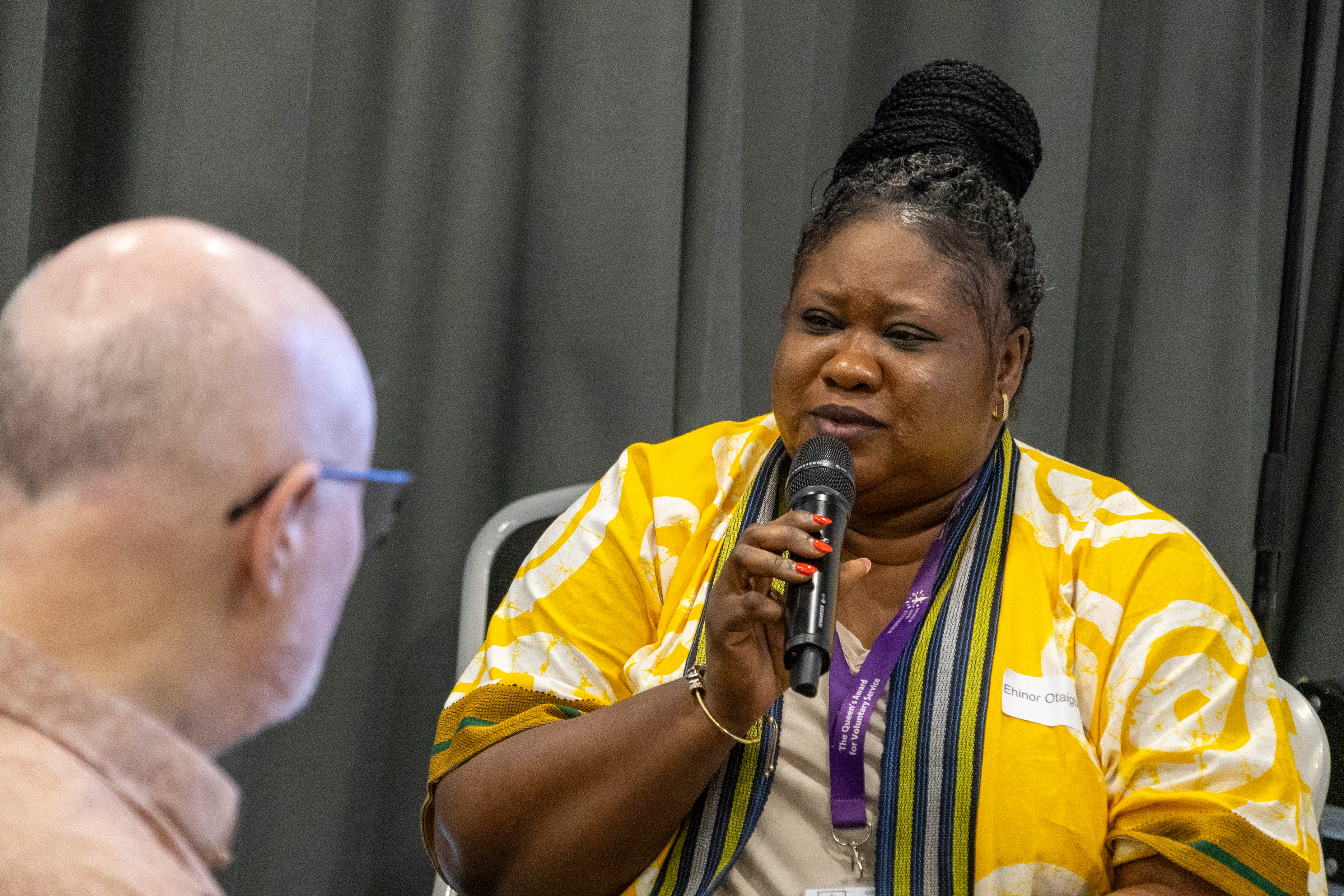 10 Ehinor Otaigbe from Wonderfully Made Woman speaking into a microphone at the People and Communities Conference