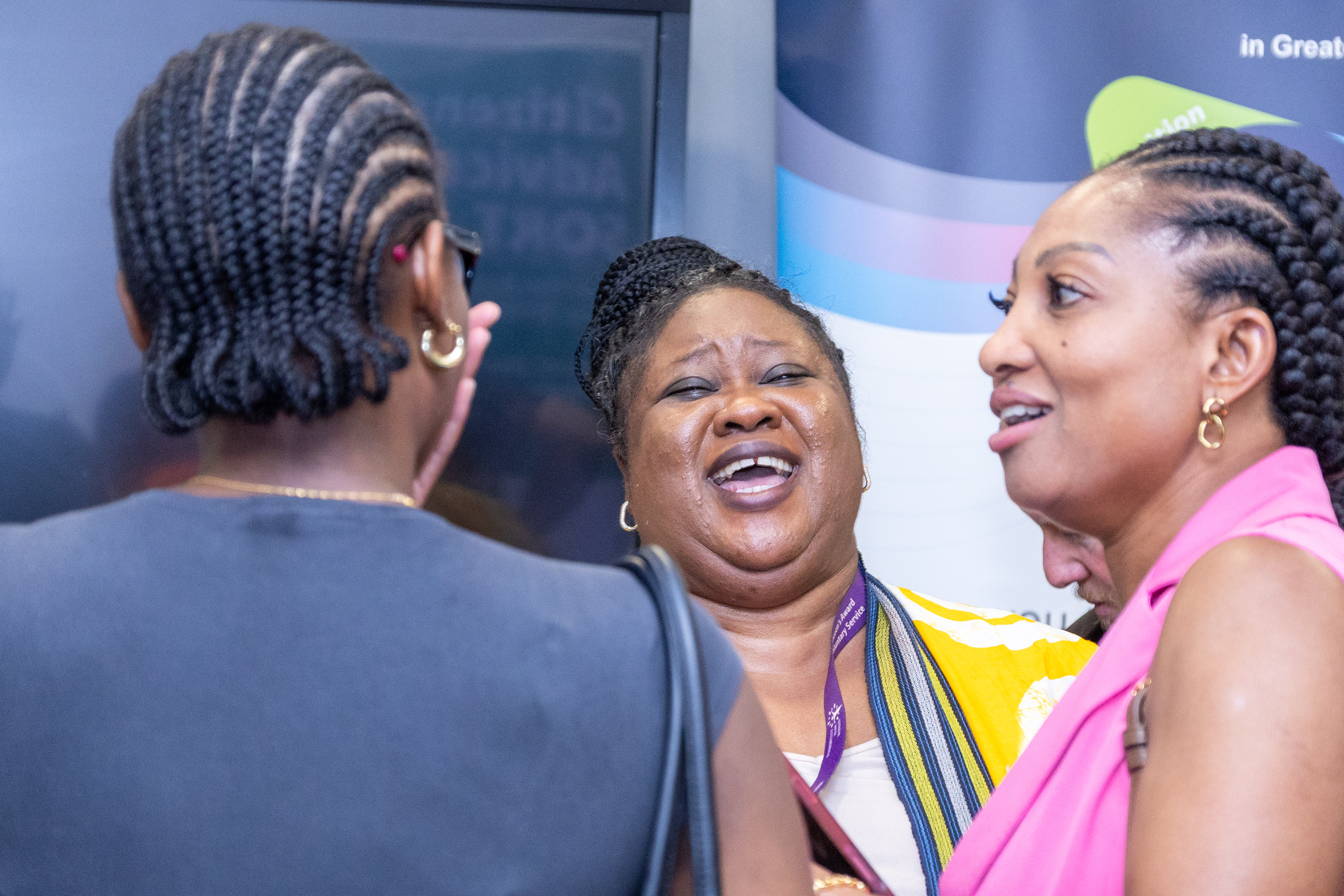 17 Group of people networking in the conference break with a focus on Ehinor Otaigbe from Wonderfully Made Woman laughing in the conversation