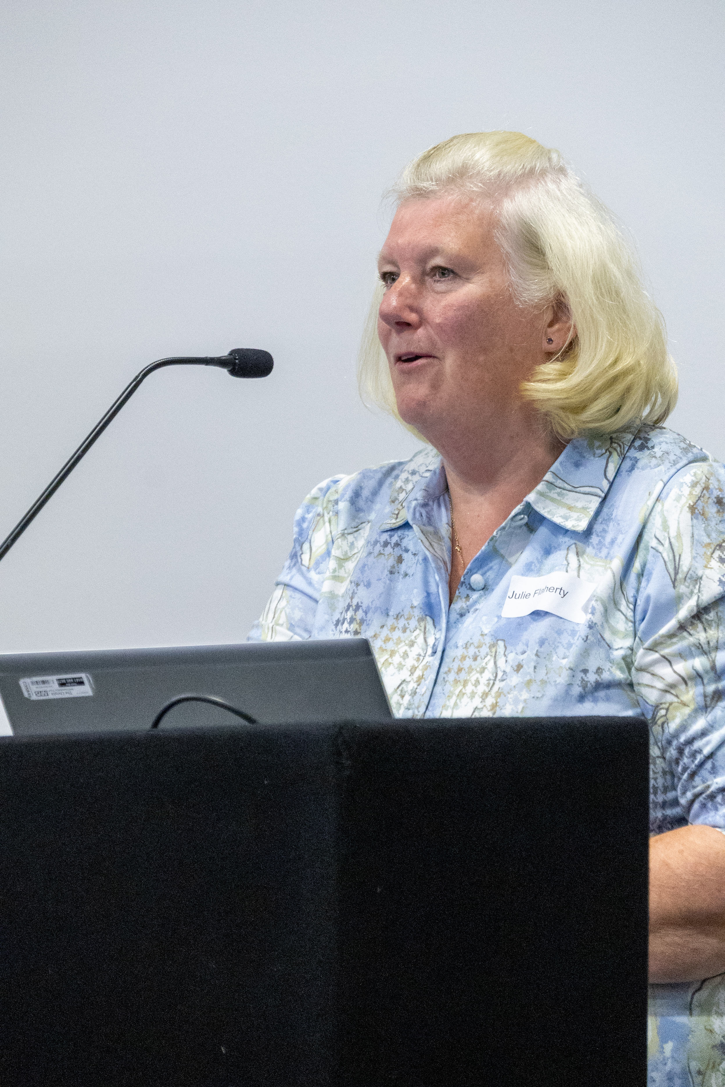 18 Julie Flaherty delivering the patient and carer perspective behind a podium at a conference