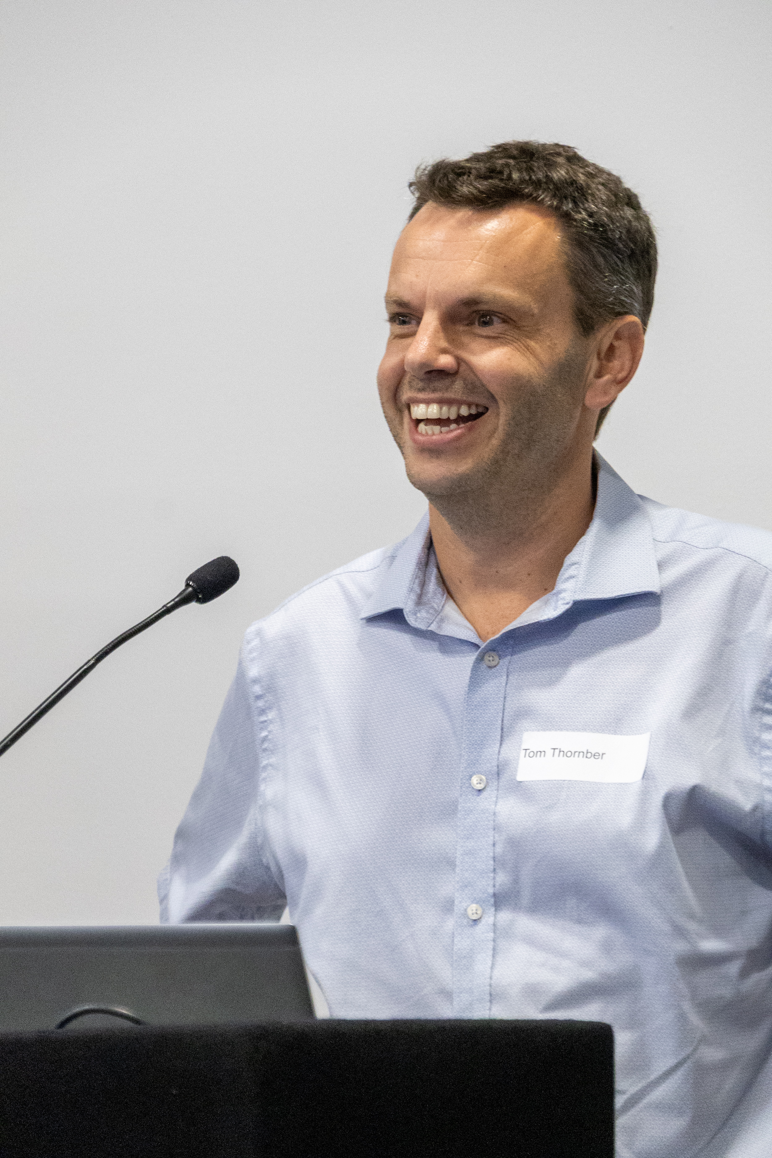 40 Close up of Tom Thornber stood behind a podium smiling at delegates