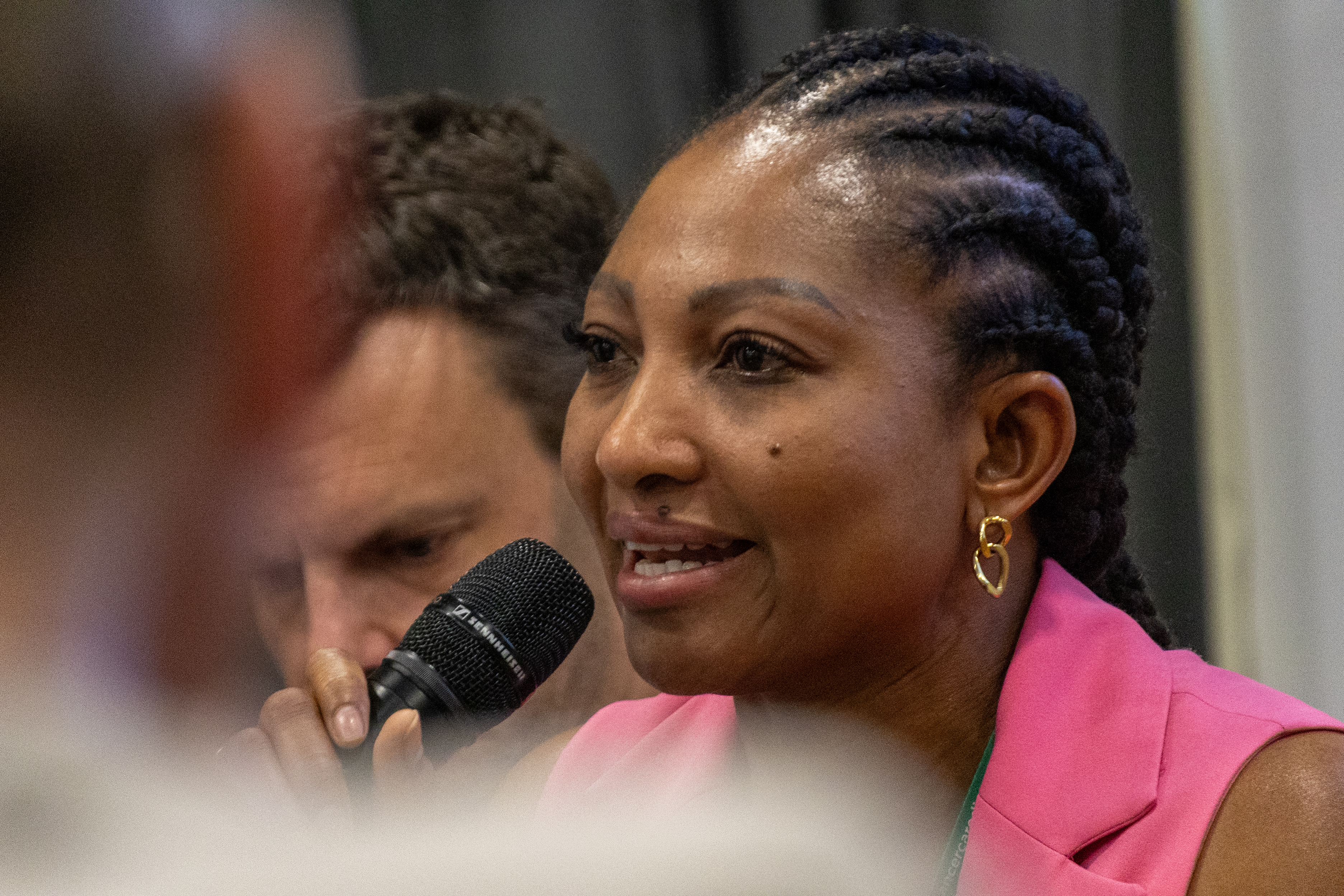 44 Close up of Laura Urhobo sat on a panel holding a microphone answering questions from the audience on a Q&A panel