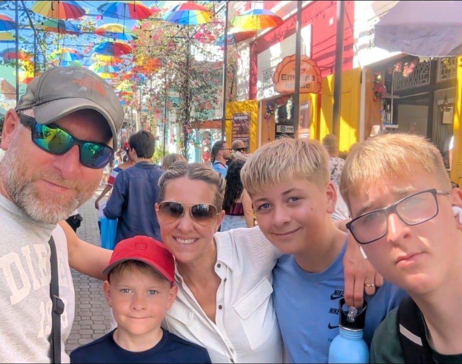 WhatsApp Image 2026-07-20 at 12.03.14 (1) Justine with her husband and three children taking a selfie while on holiday
